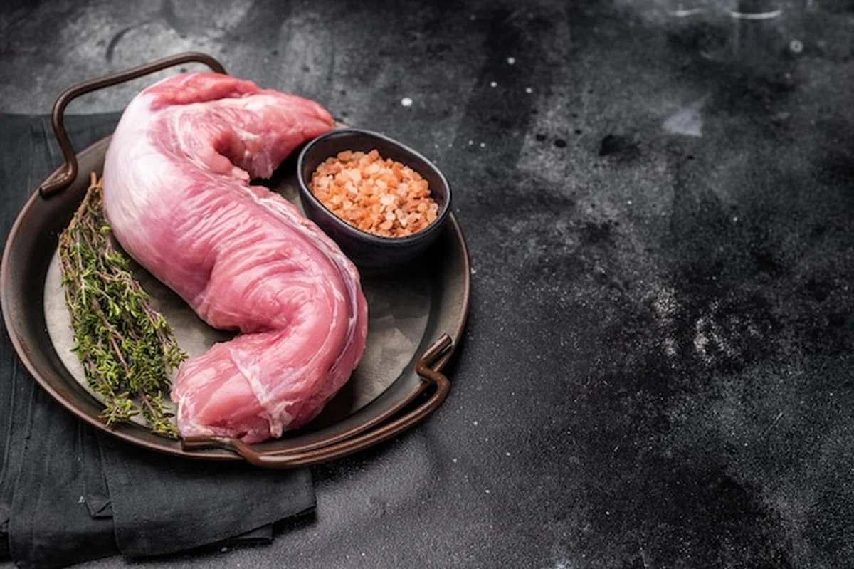 Świeży filet z polędwicy wieprzowej na czarnym tle, idealny do marynowania i grillowania